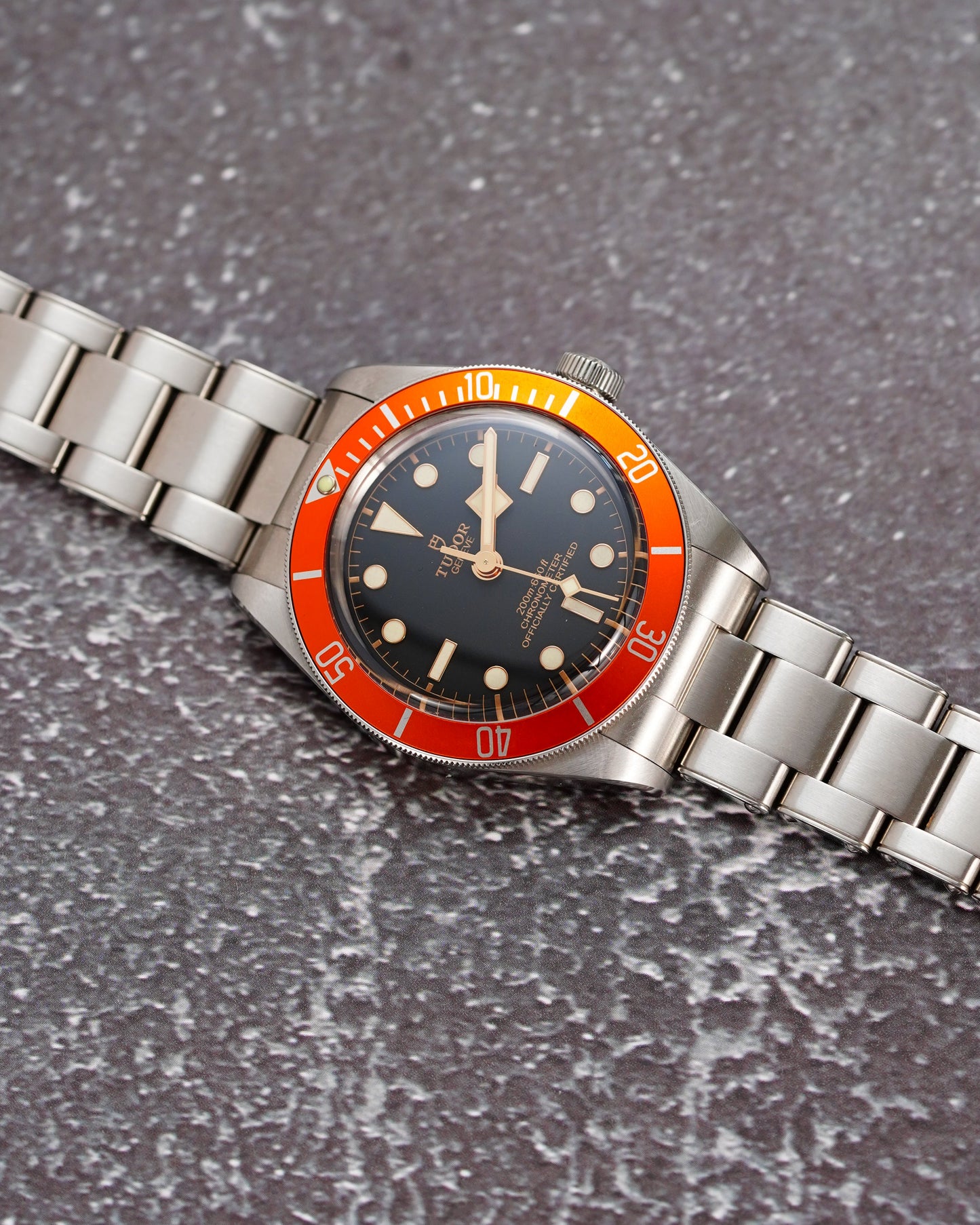 Wristwatch with metal strap on a textured gray surface