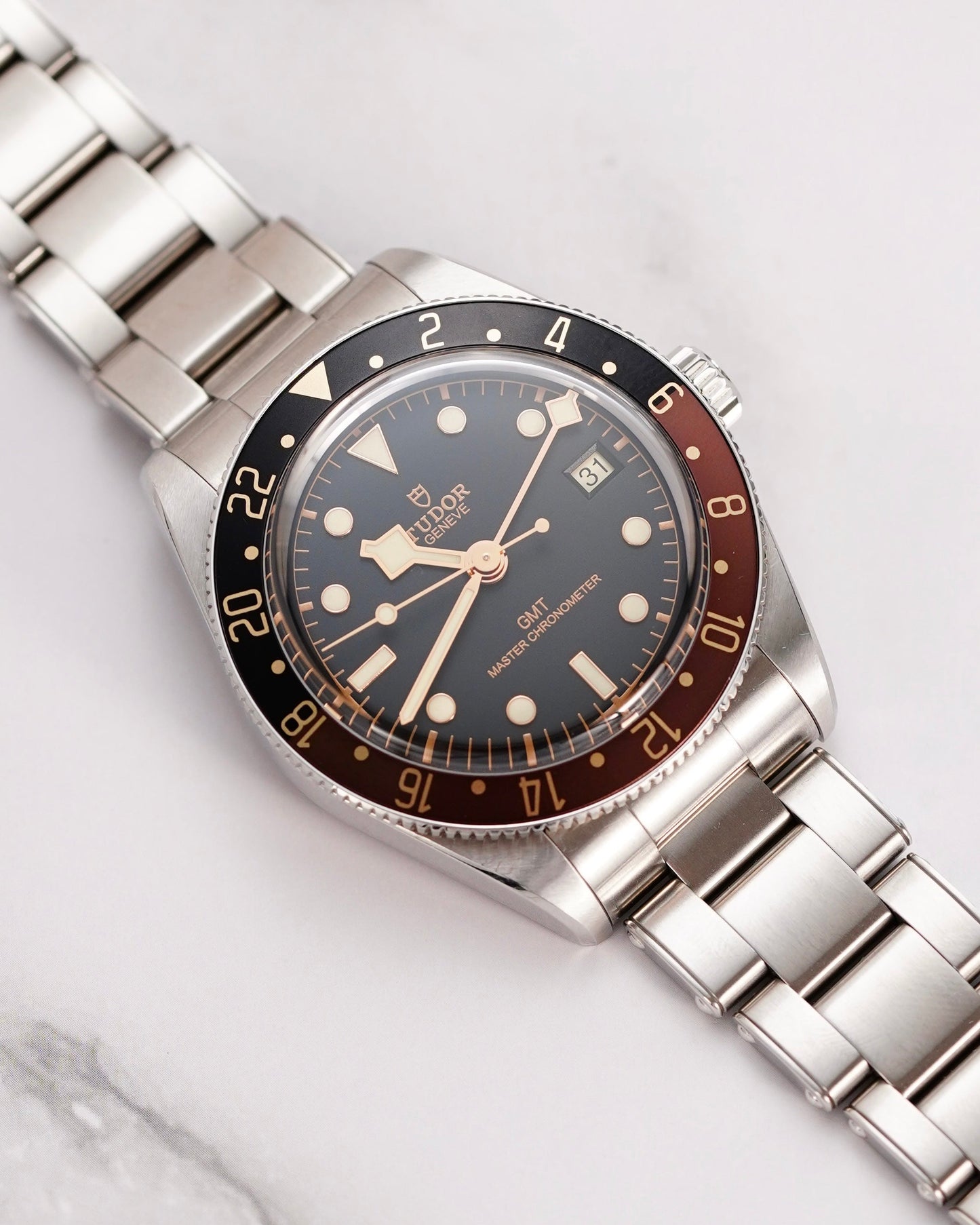 Silver watch with a black face and red accents on a light gray background