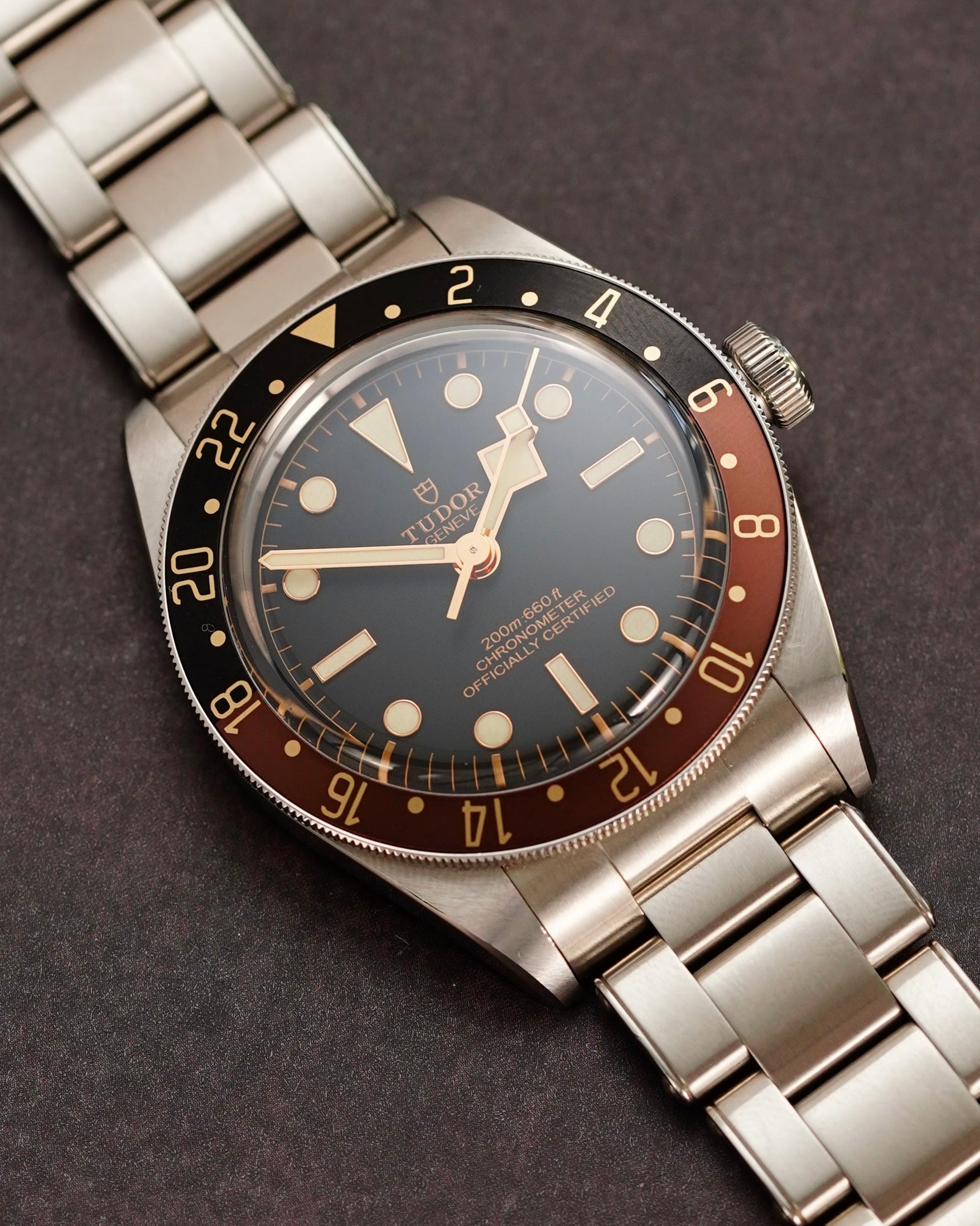 Vintage-style wristwatch with metallic band on a dark background