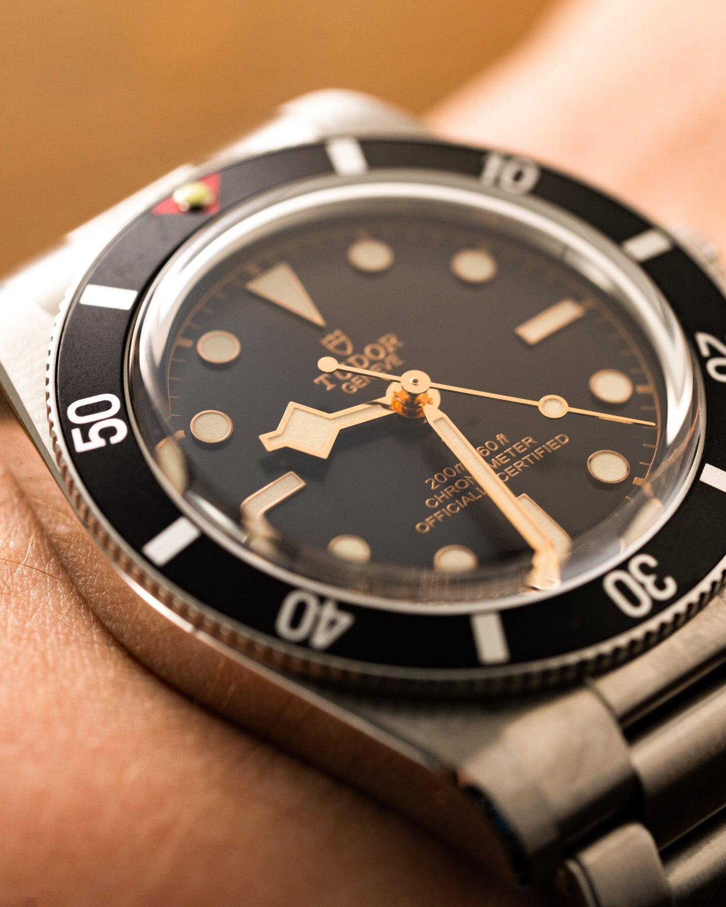 Close-up of a wrist wearing a vintage-style watch with a black dial and silver case.