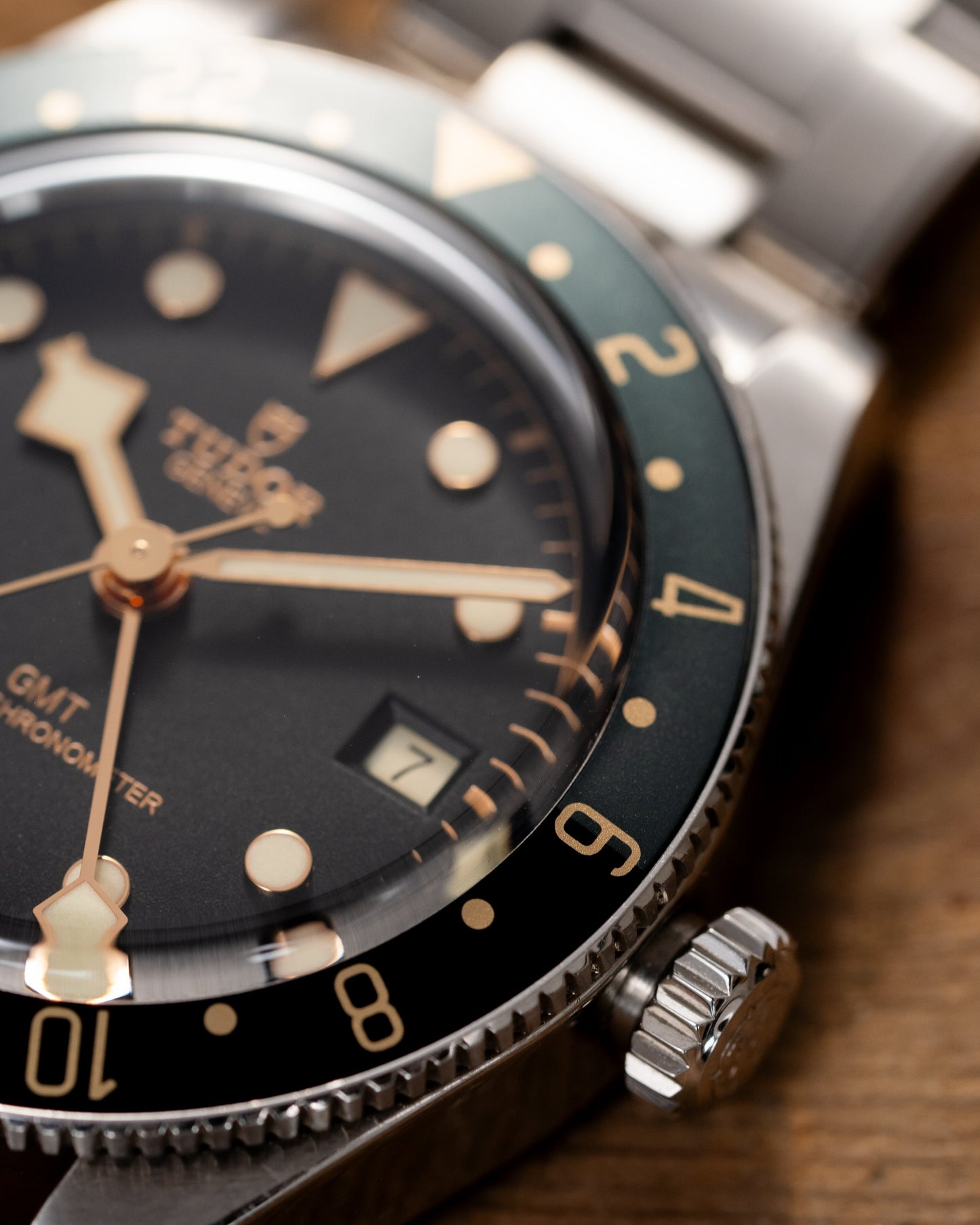 Vintage watch with black dial and silver case on a wooden surface