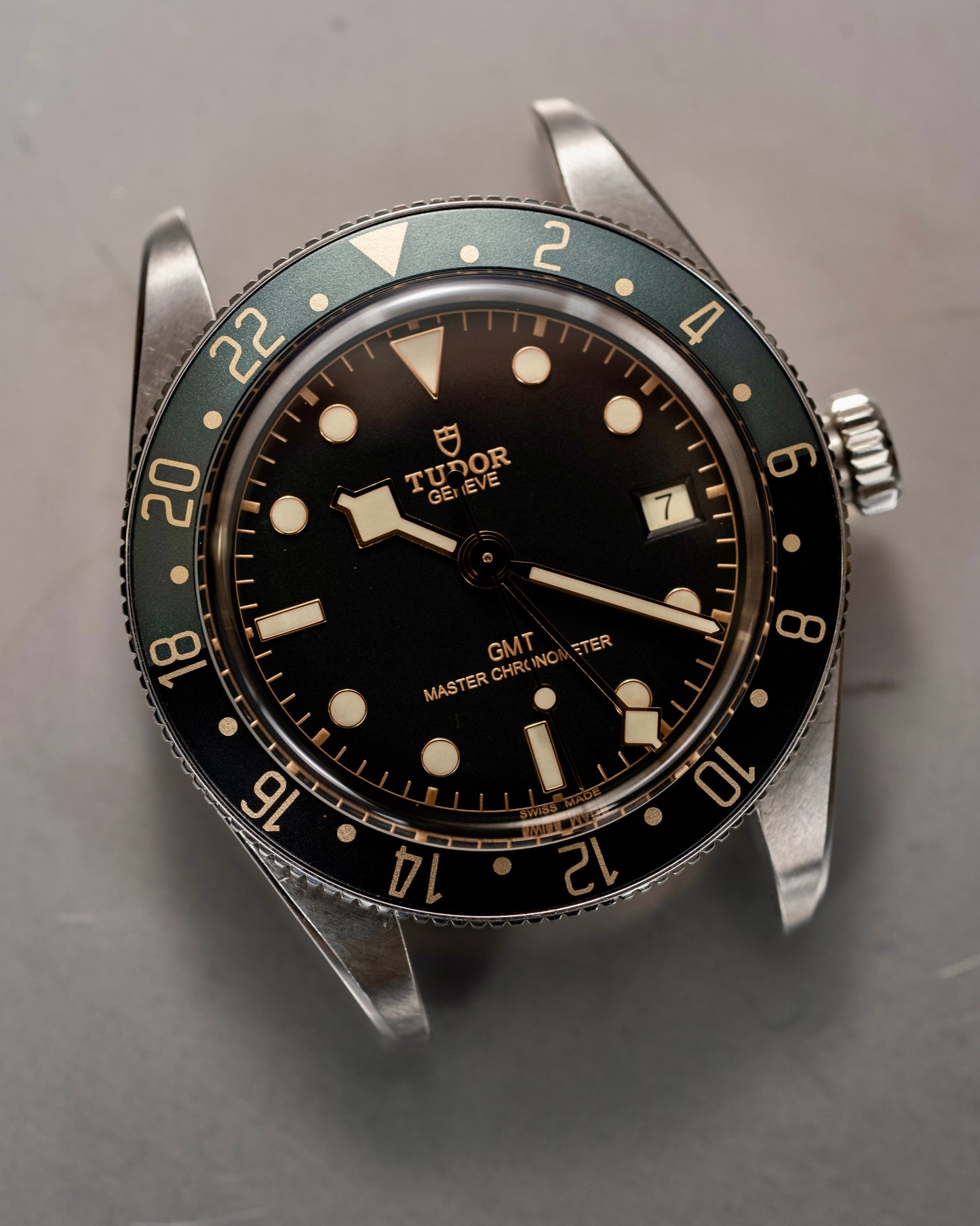 Tudor watch with black dial and silver case on a gray background