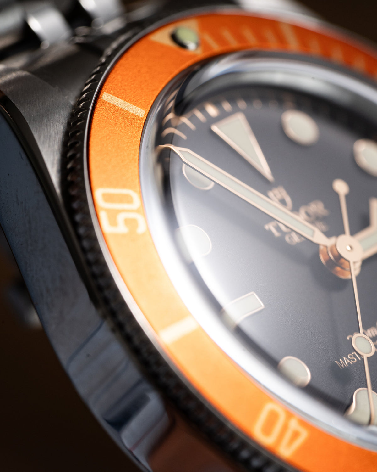 Close up of a Tudor watch with a bright orange bezel